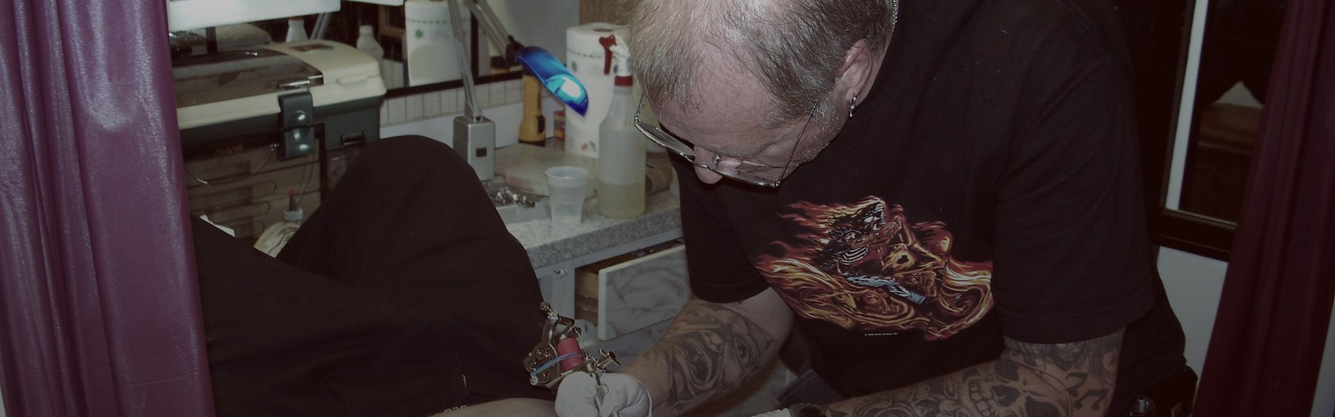 Artista tatuando con guantes azules