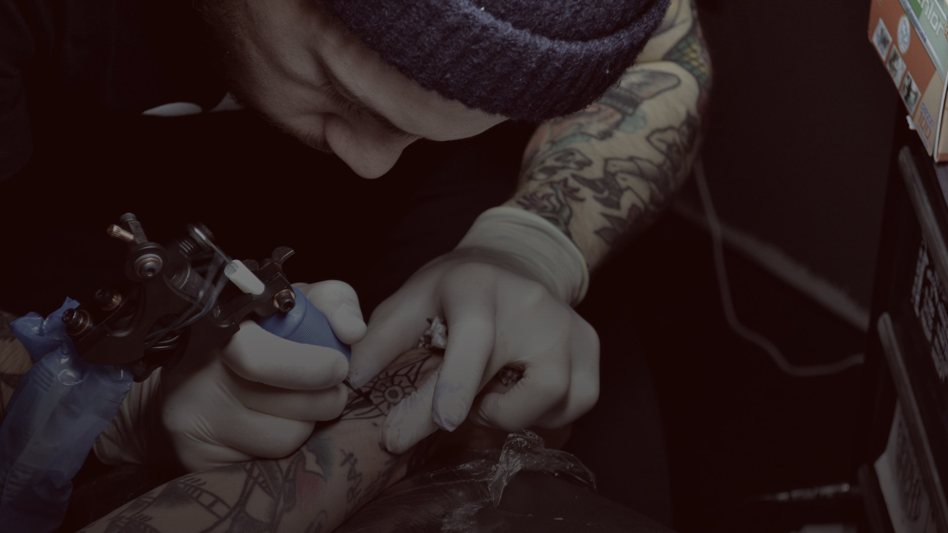 Artista tatuando un antebrazo en un estudio